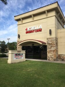 Attractive commercial building with Spanish architectural style and "Medella Urgent Care" sign over the arched entrance and on a sign in front