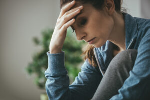 Woman clutching her forehead area with her right hand as if in pain